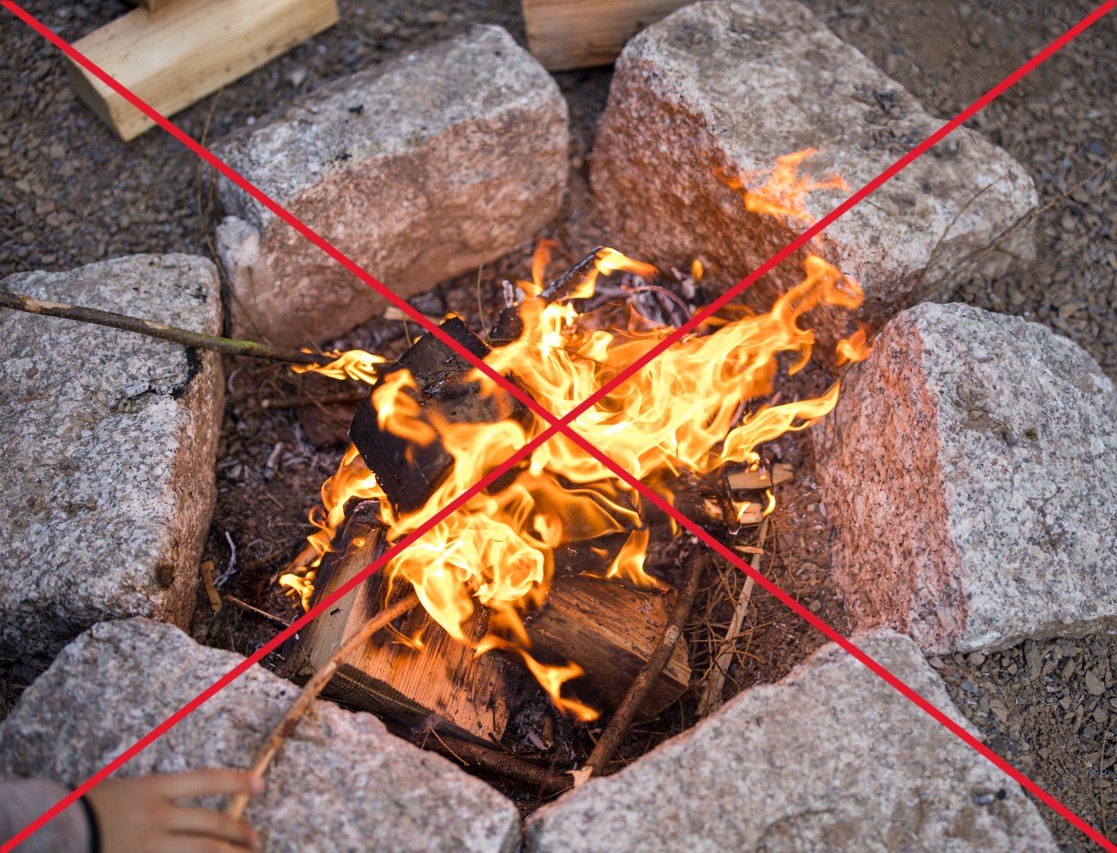 Feuer in Feuerstelle mit mit einem roten Kreuz darüber
